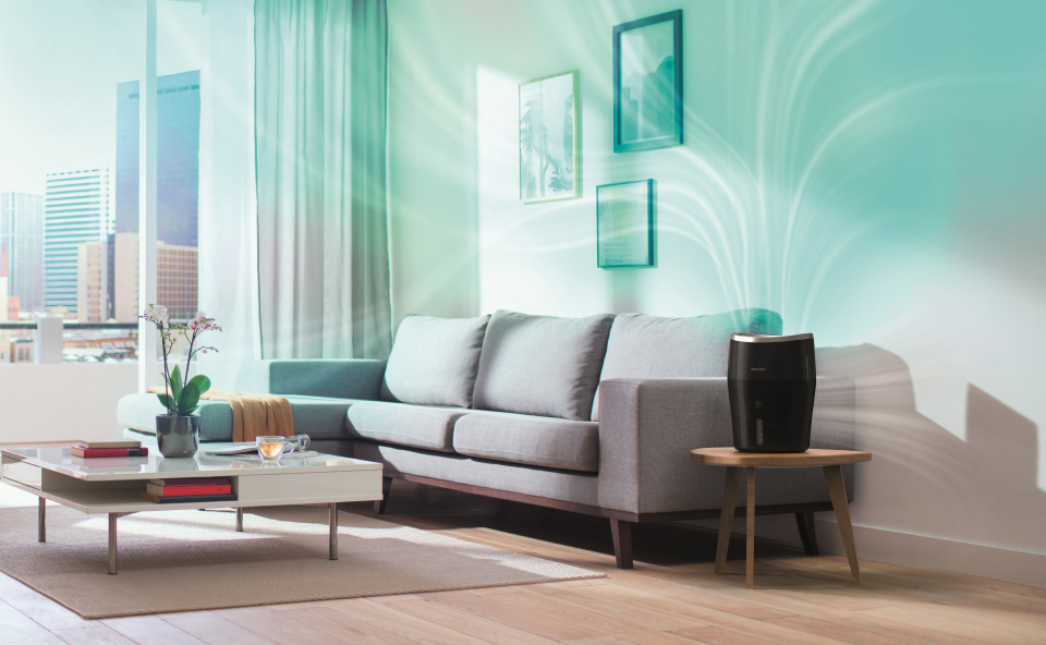 Uruchomiony duży czarny nawilżacz powietrza stojący w salonie