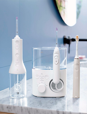 Kobieta trzymająca irygator do zęb&oacute;w Philips